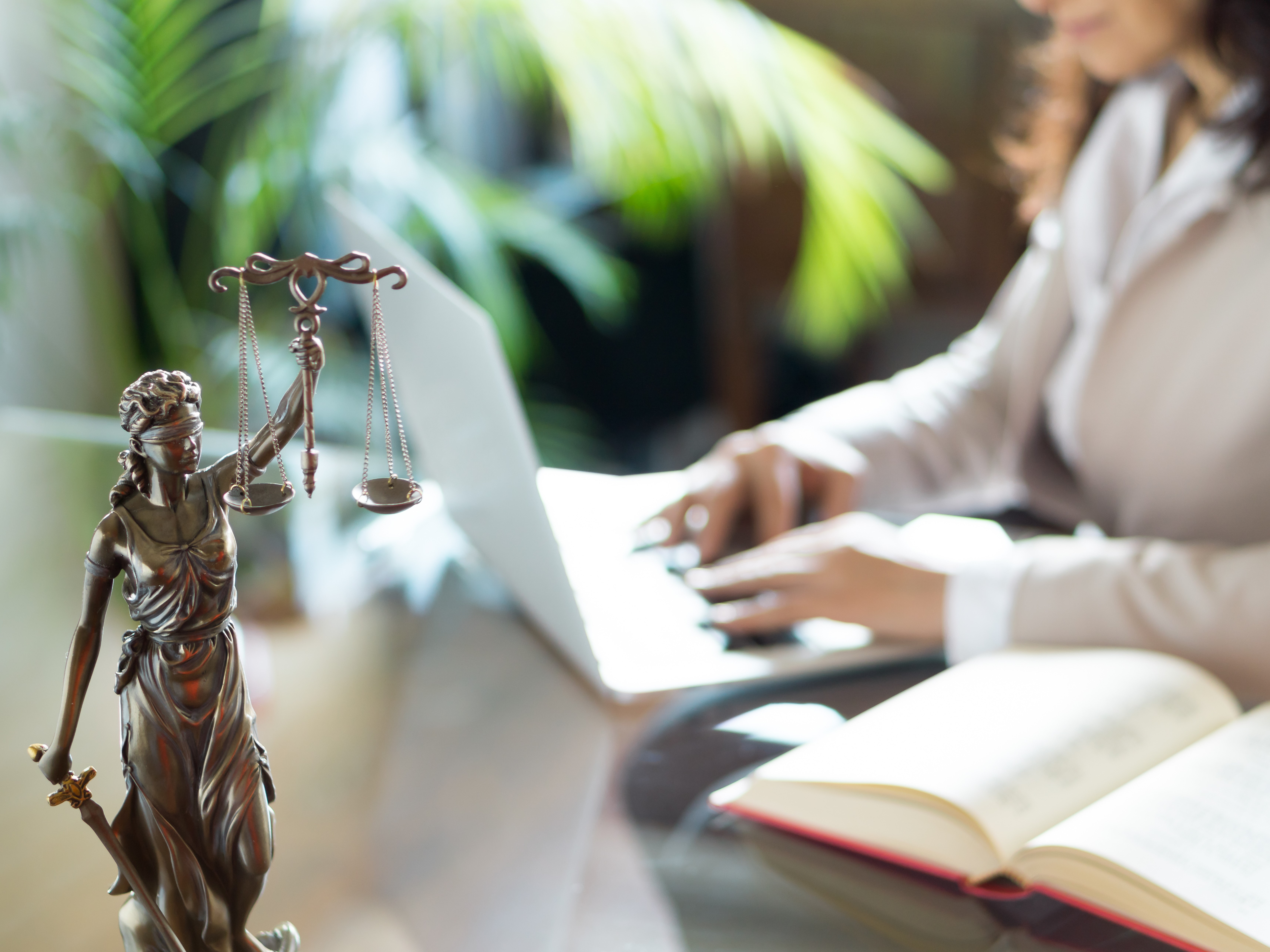 Femme à un bureau avec des livres et une balance