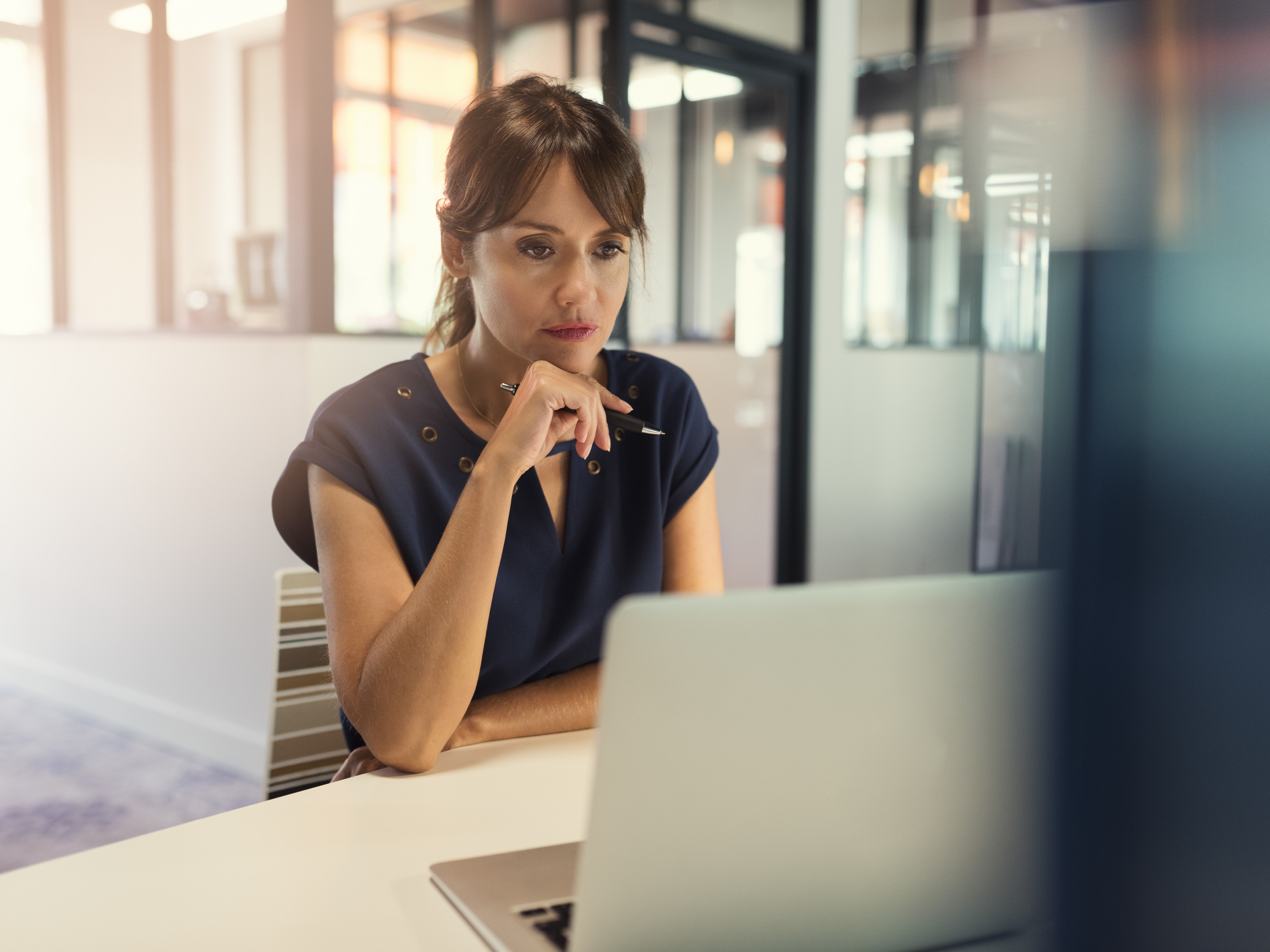 Une personne pensive avec un ordinateur portable