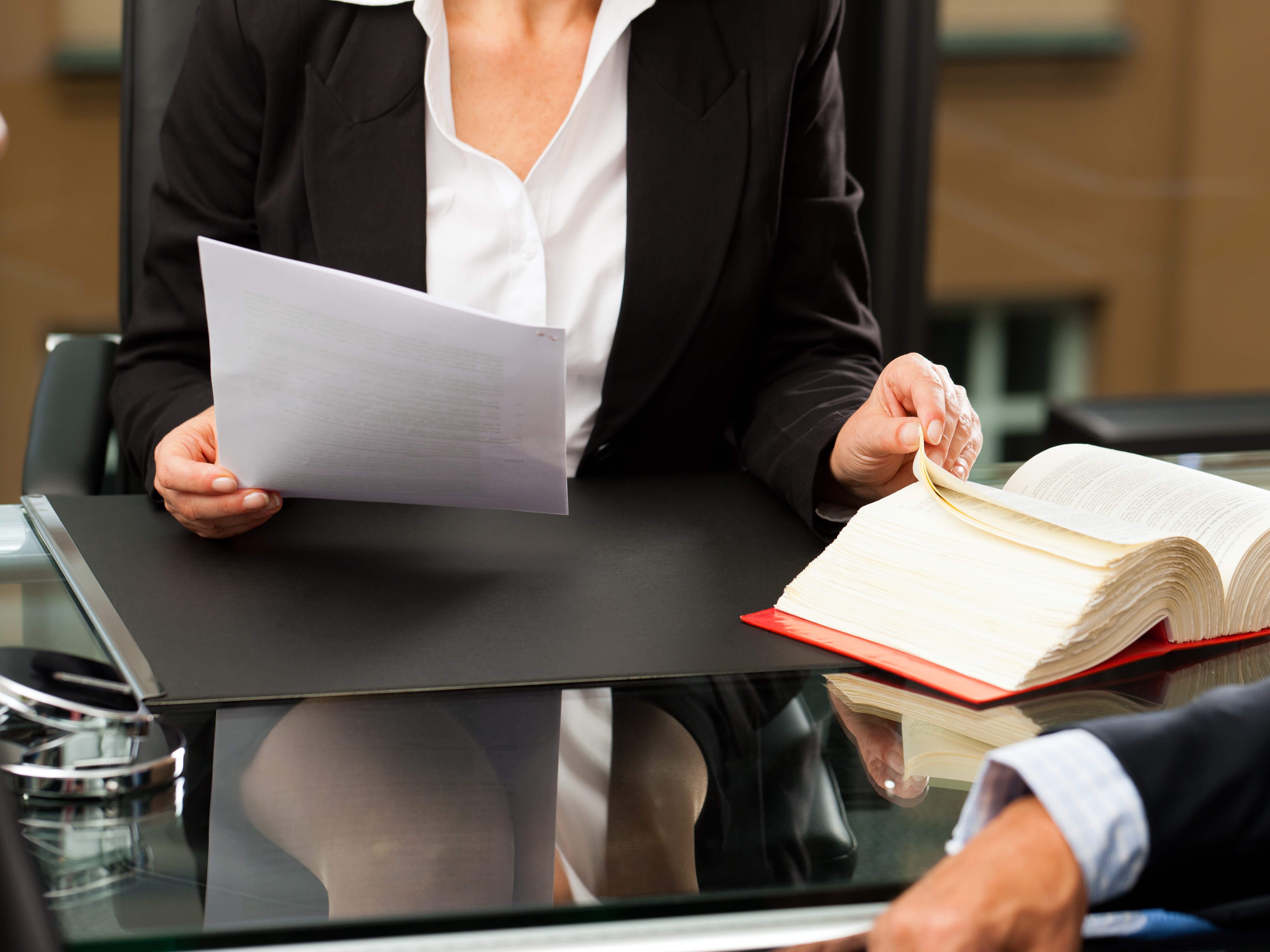 A person sitting at a desk reading documents.