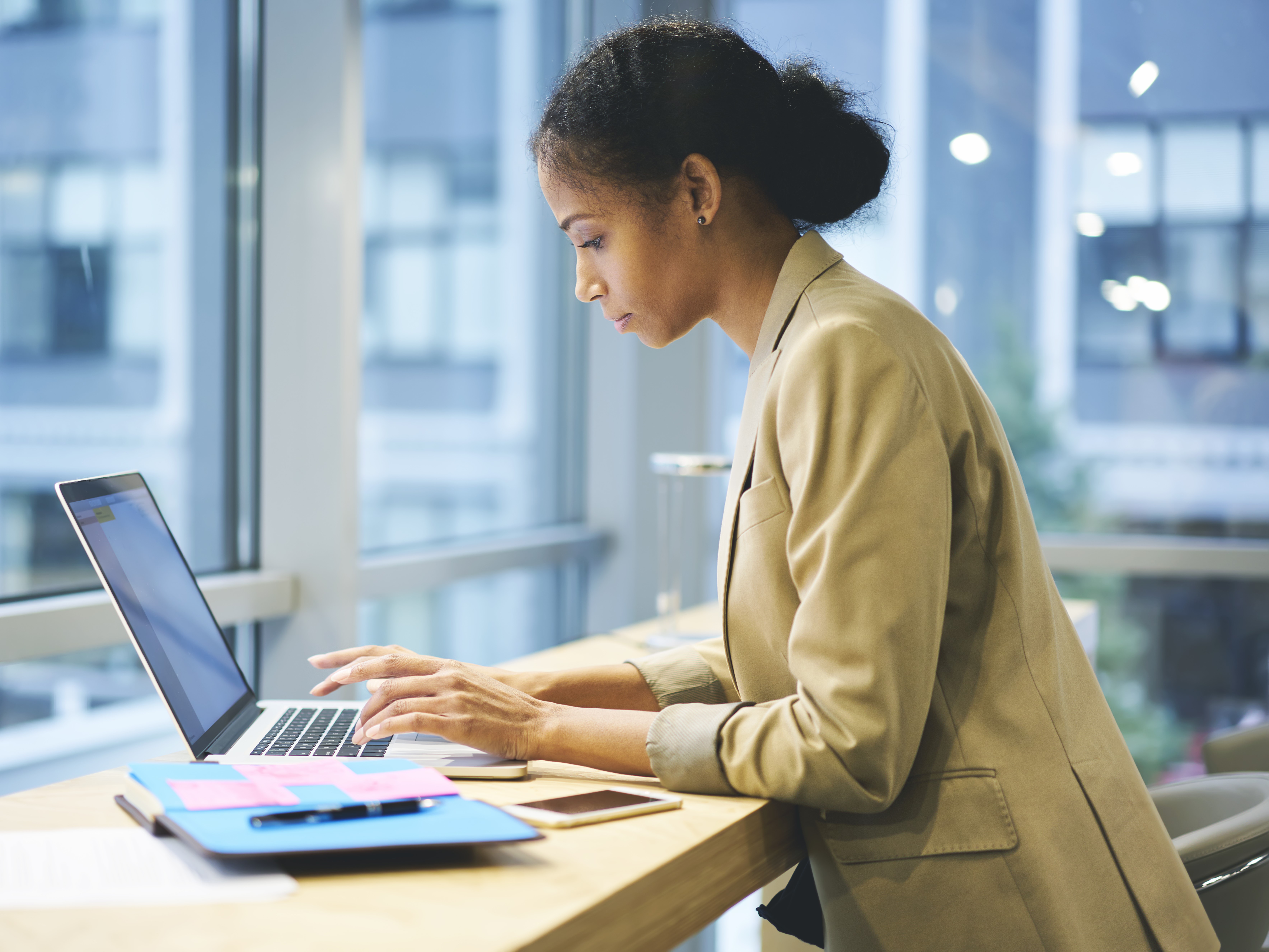 A woman writting on a laptop.