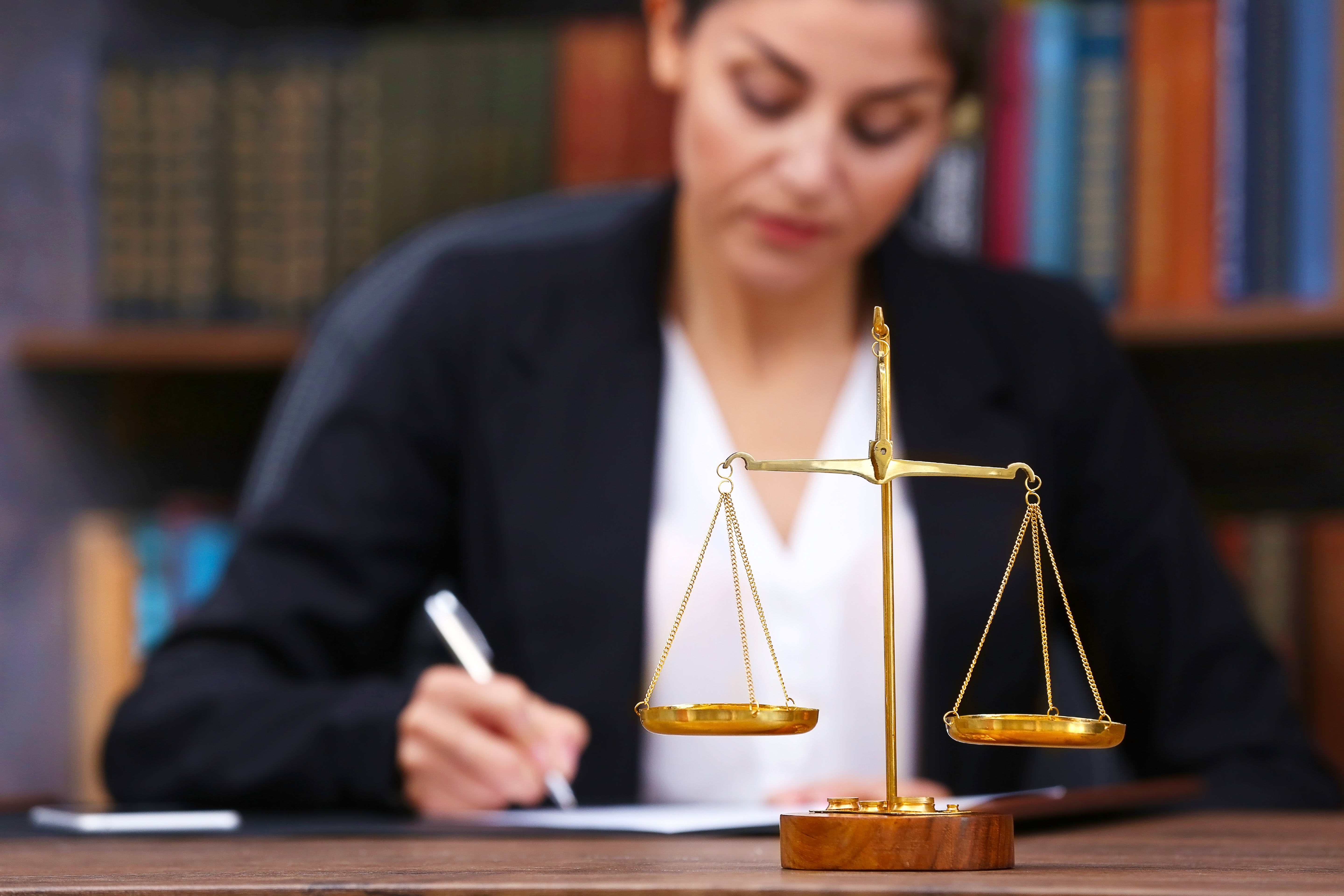 Une femme écrivant sur un papier avec une balance.